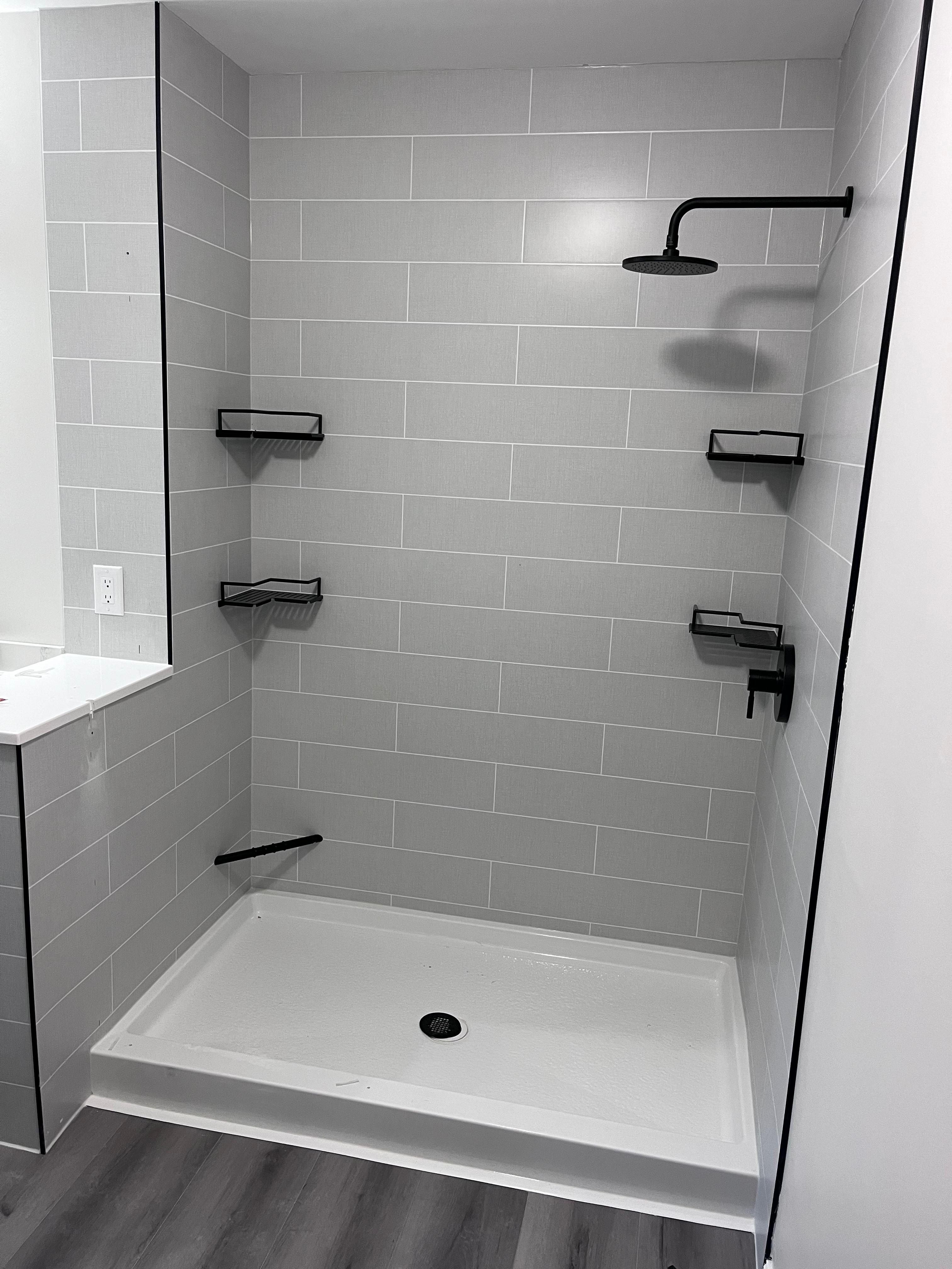 After: completed frameless shower enclosure with matte black hardware