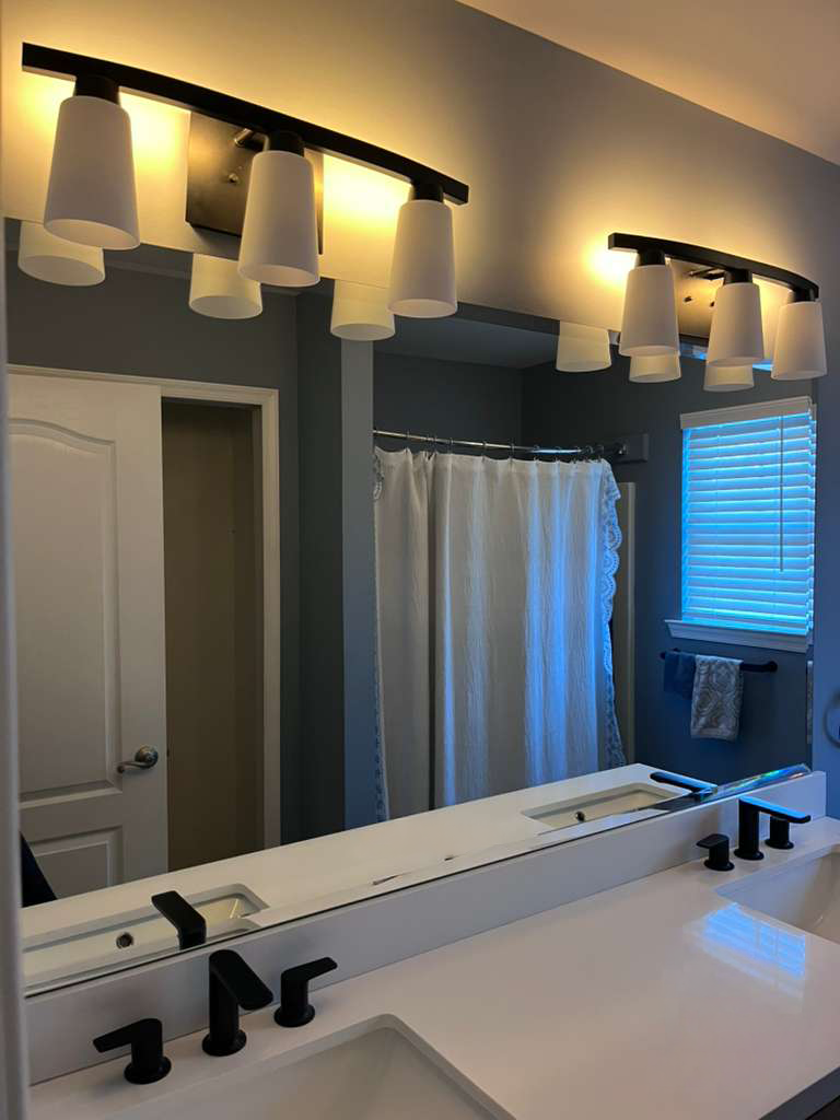 Custom bathroom vanity mirror installation with matte black fixtures
